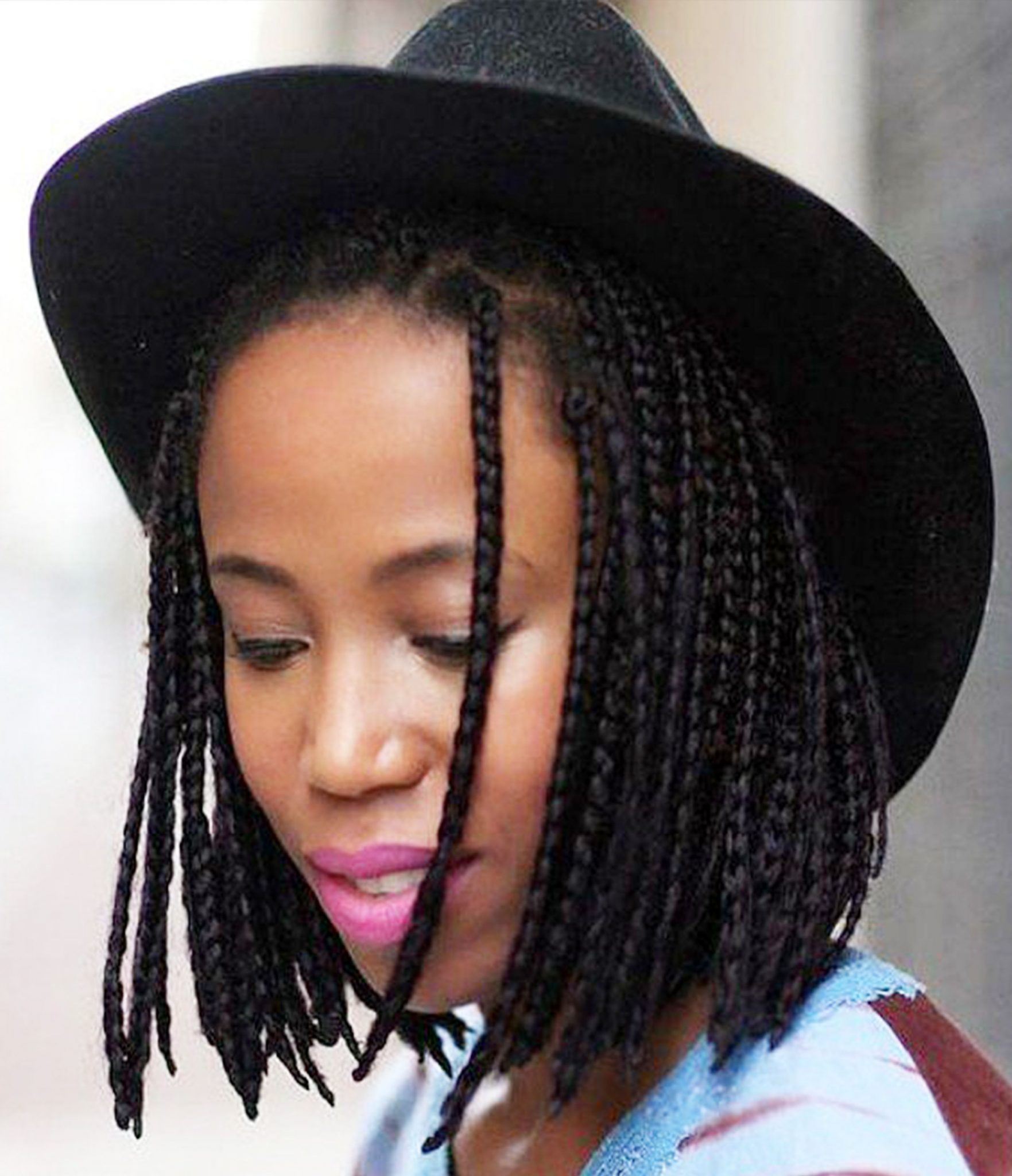 A woman with a straight light brown bob with colorful box braids sections